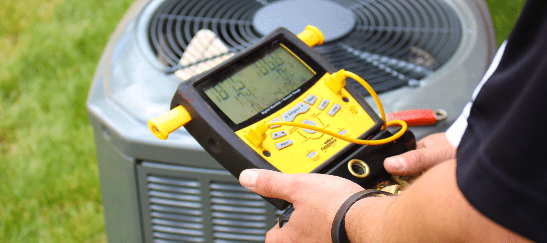 technician using a yellow HVAC diagnostic tool to measure performance near an air conditioning unit outdoors