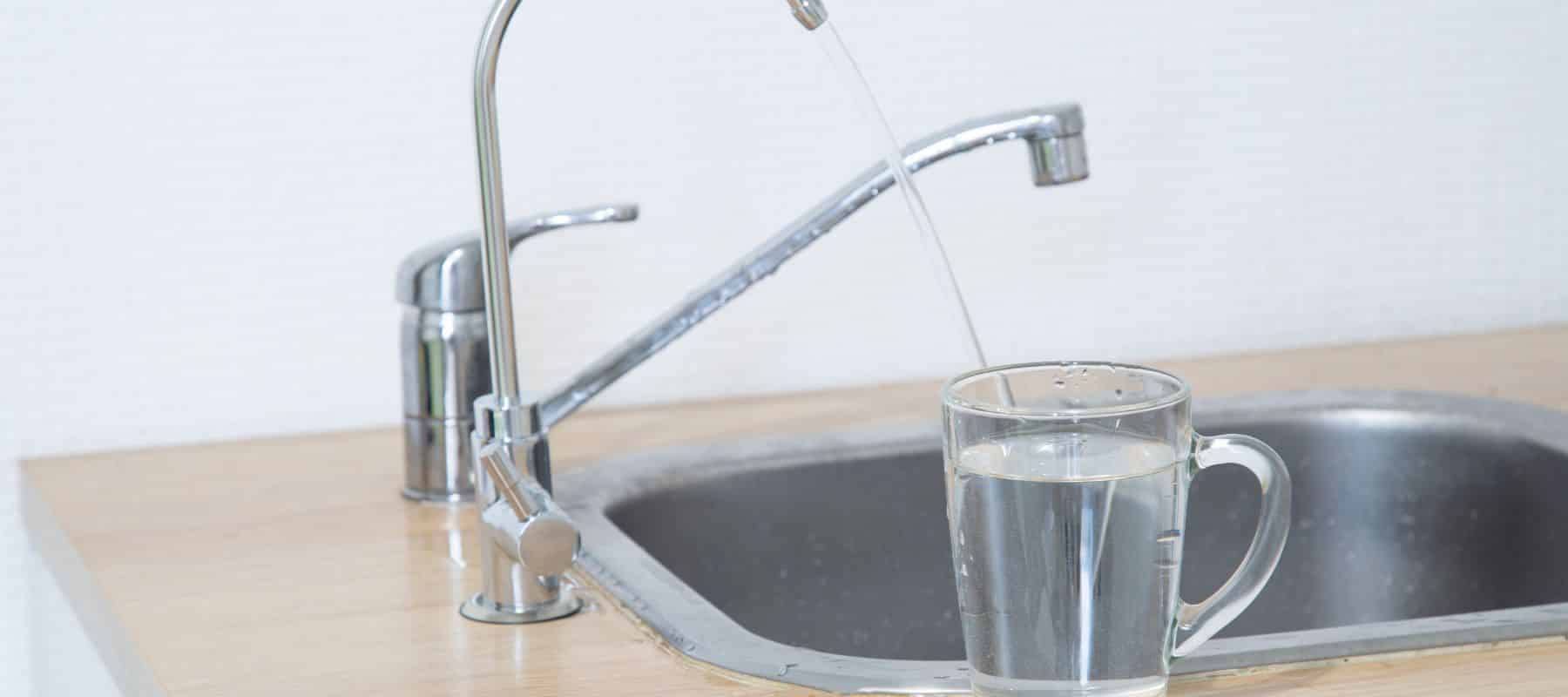 clear water from kitchen sink going into glass cup