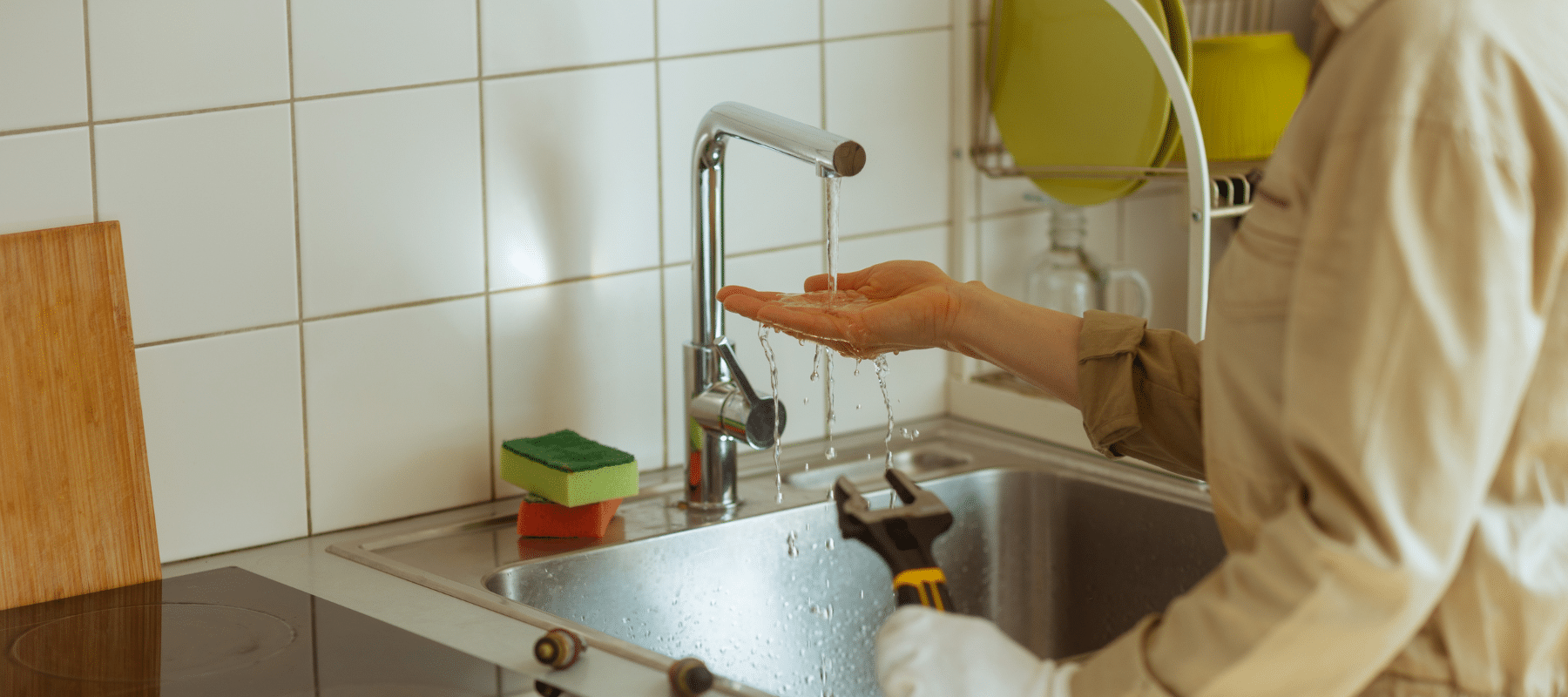 Person checking water flow at sink