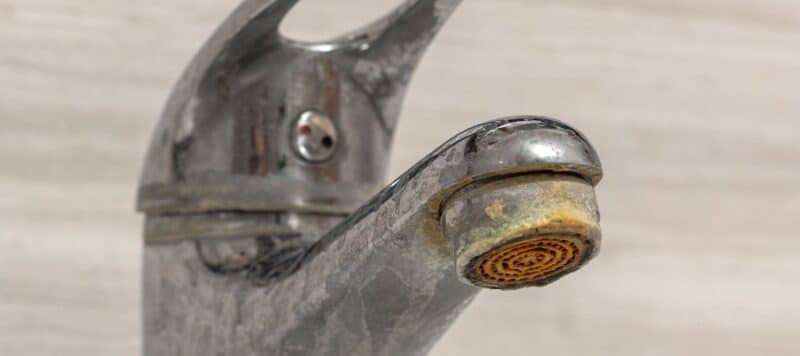 Faucet with hard water stains visible.