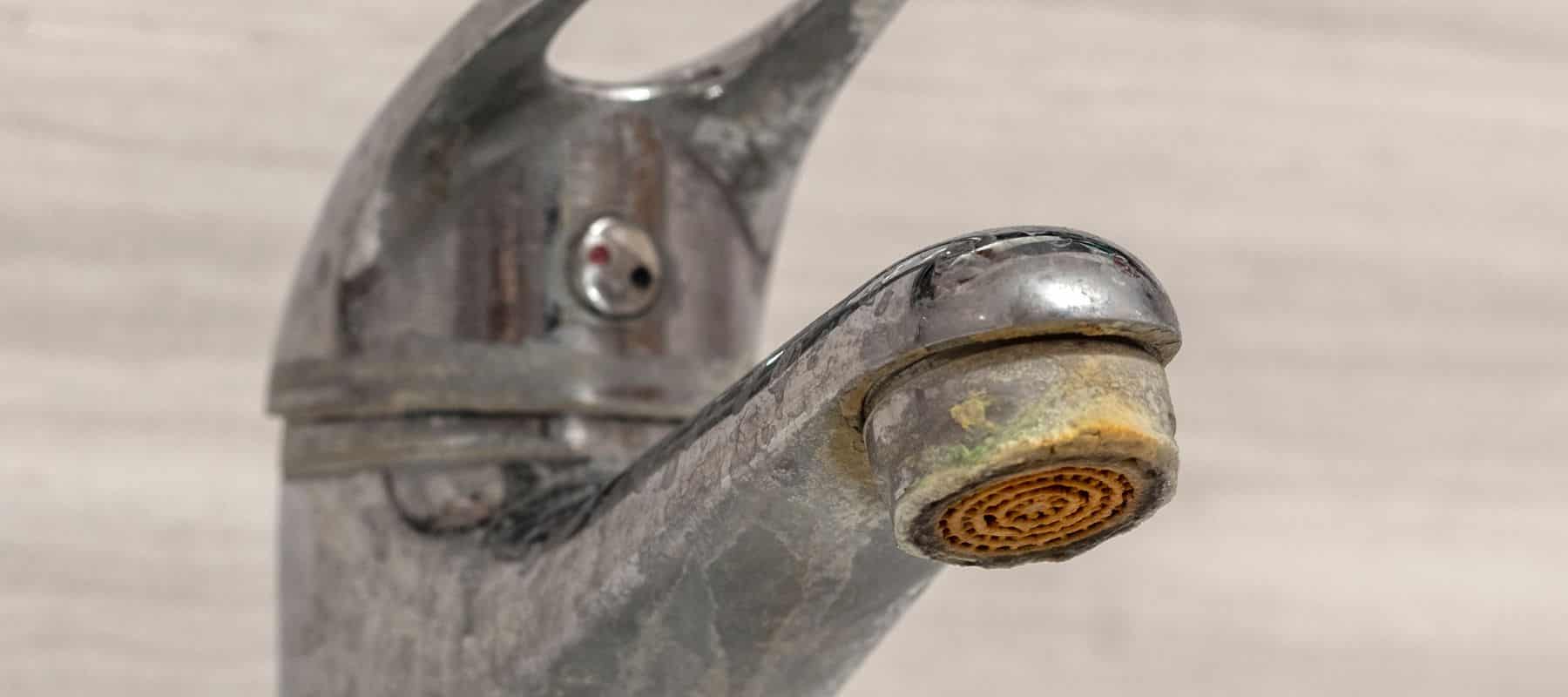Faucet with hard water stains visible.